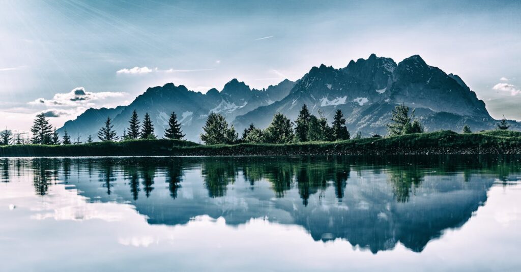 Stunning mountain landscape reflected in a serene lake under a clear sky.